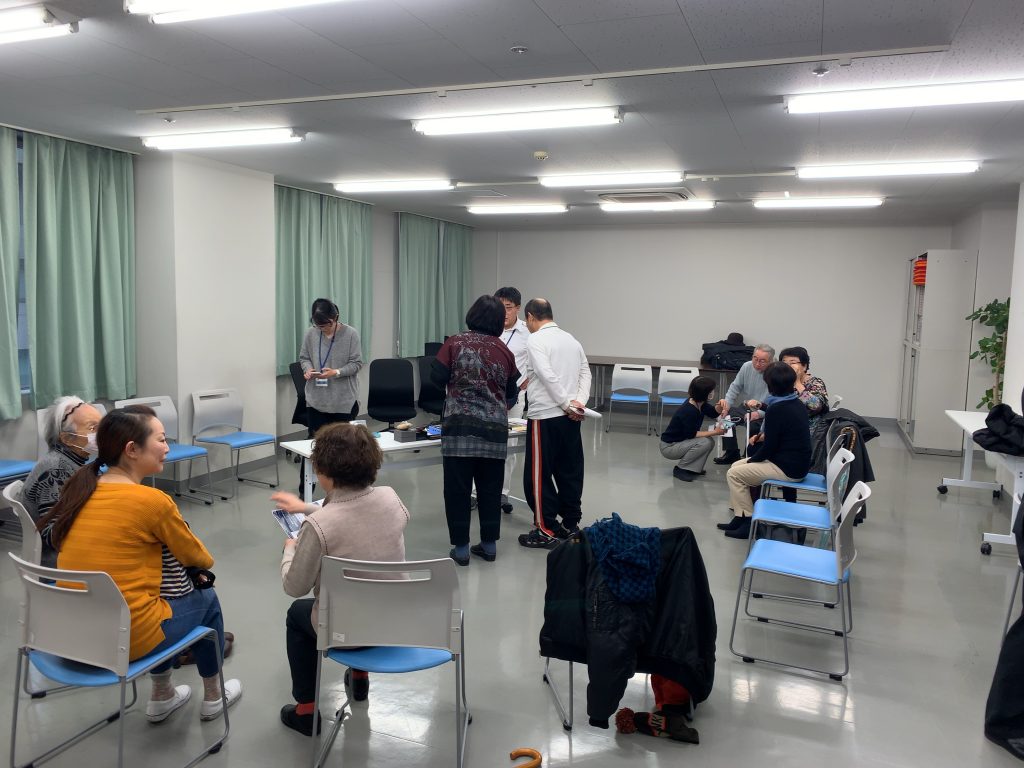 視覚障害者が個別に便利グッズの説明を受ける画像