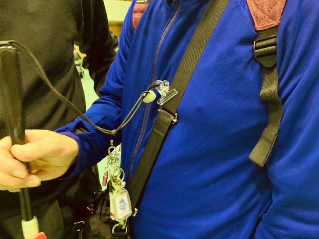 白杖の紐についたクリップを服に挟んでいる画像