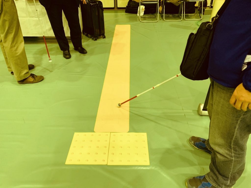 シートタイプの点字ブロックに白杖を沿わせている画像