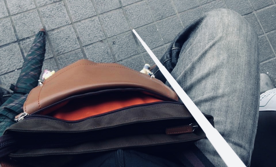 座った足の間に白杖を立てている渡辺さん目線の画像