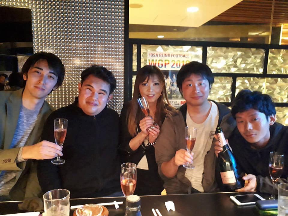 バーでバーテンダーと常連さんと一緒に記念撮影をするはじさん