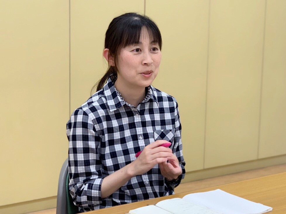 机に座って話をする小倉さん