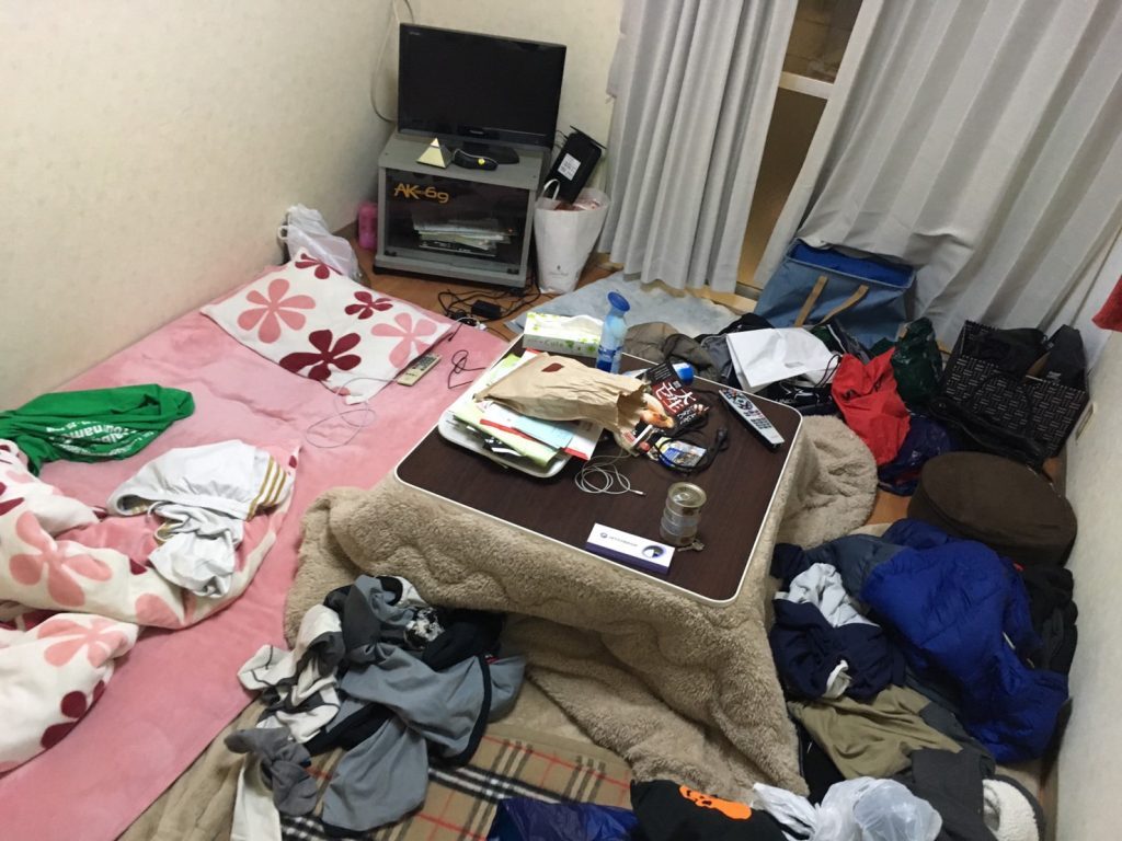 山口りょうがくんの清掃前の部屋。机やふとんの上に色々なものが散乱している画像。