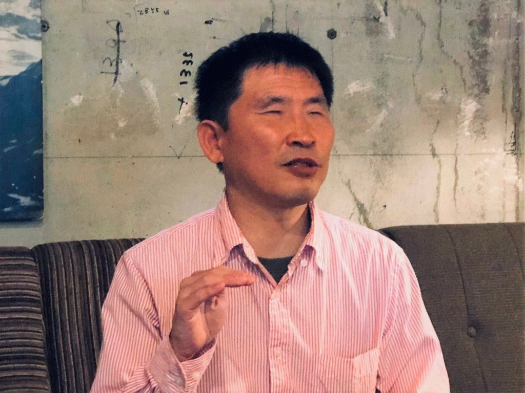 真面目な表情でジェスチャーを交えながらお話しする大川さん