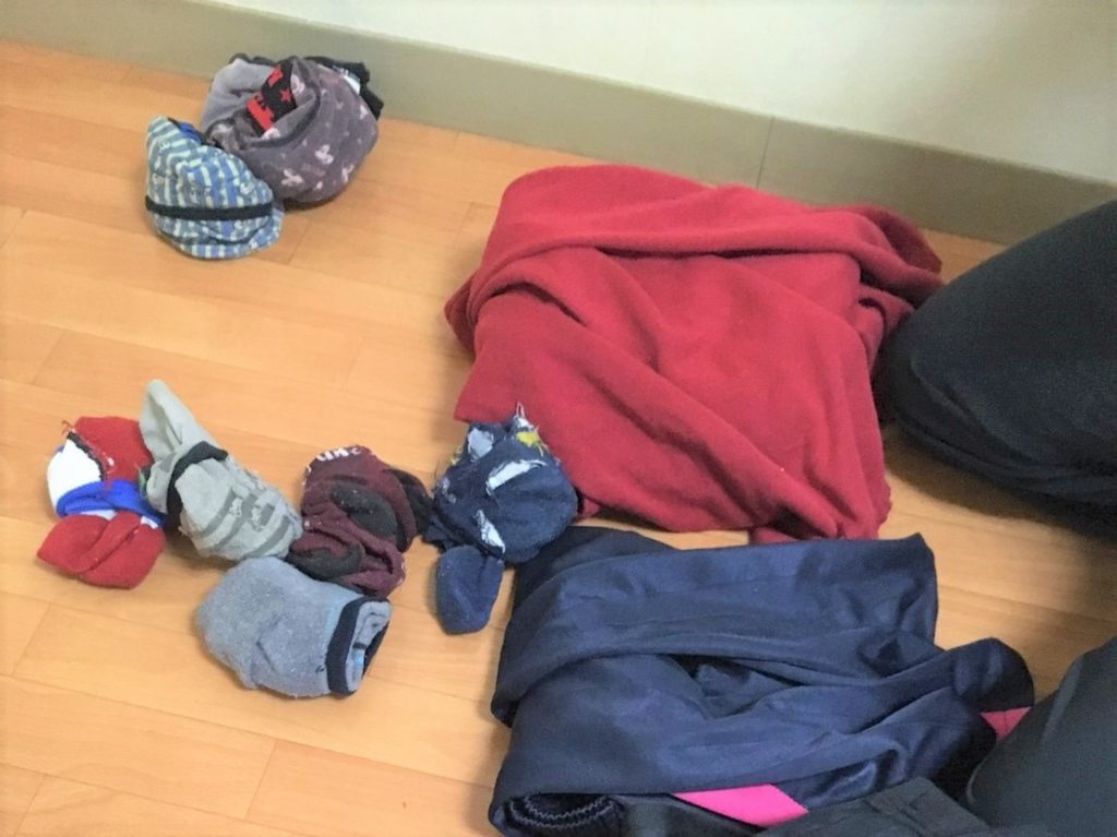 色々な色の靴下や服を畳んで収納する前の画像