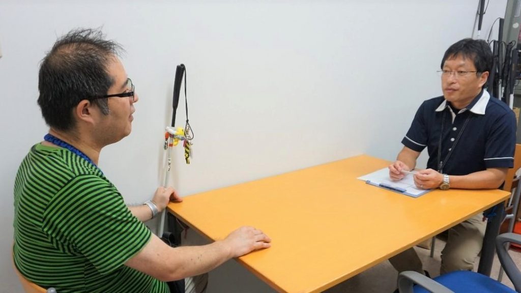 佐藤訓練士と渡辺が対面で話をしている画像。