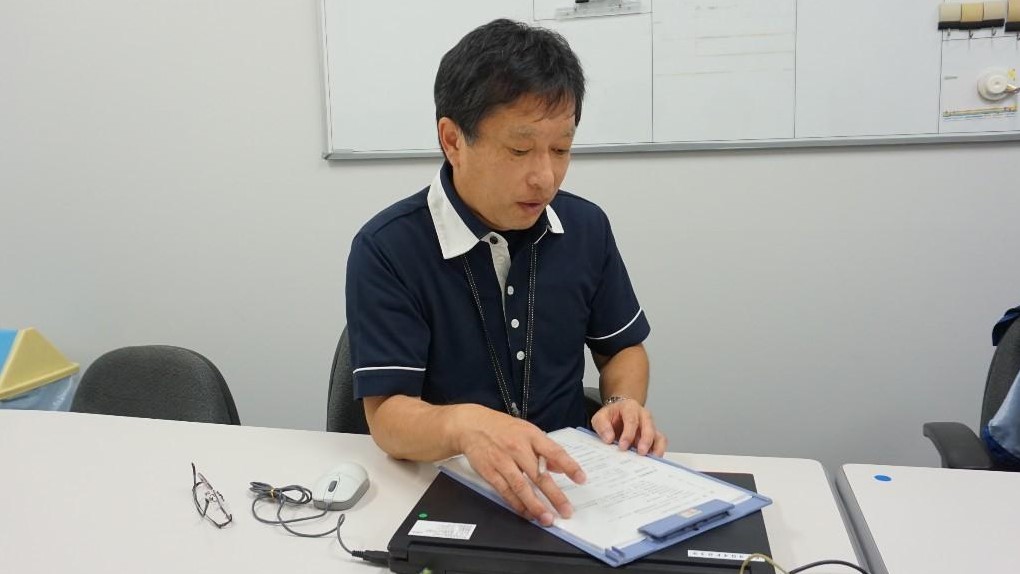 佐藤訓練士が書類を見ながら説明している画像