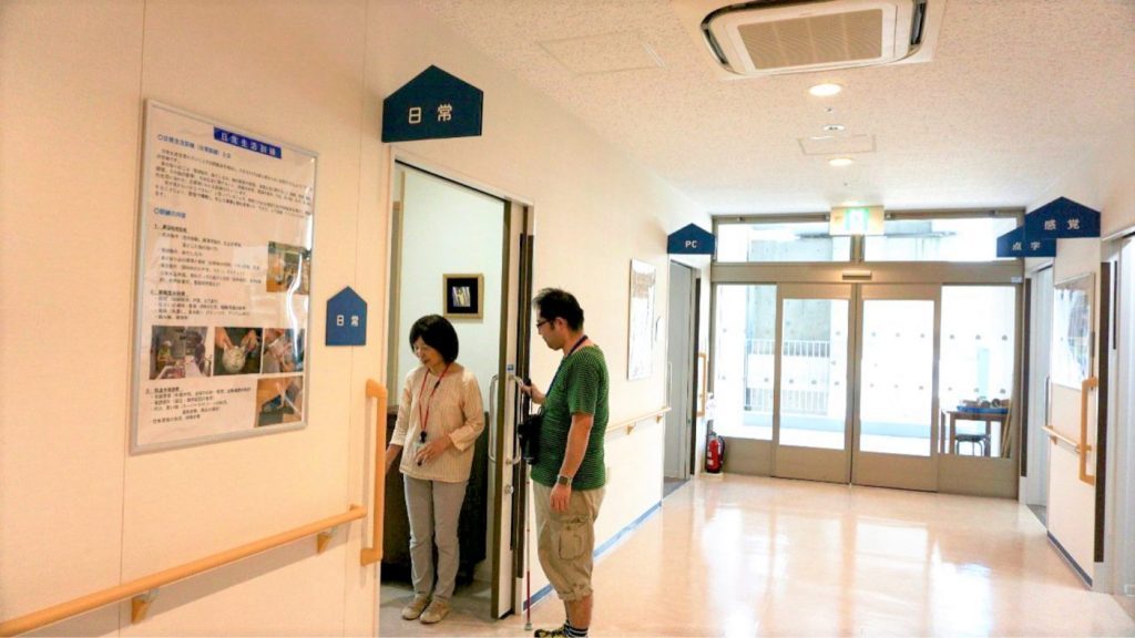 日常訓練室の入り口で、角石訓練士と渡辺が写っている画像。