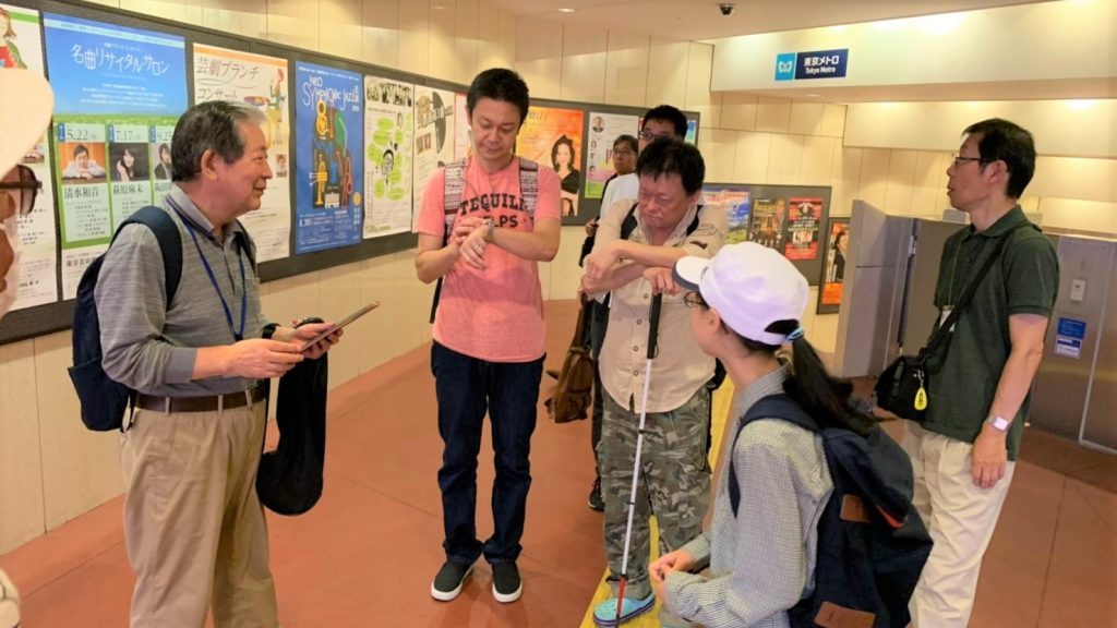 時計を見ながら時間を確認するボランティアさんの画像