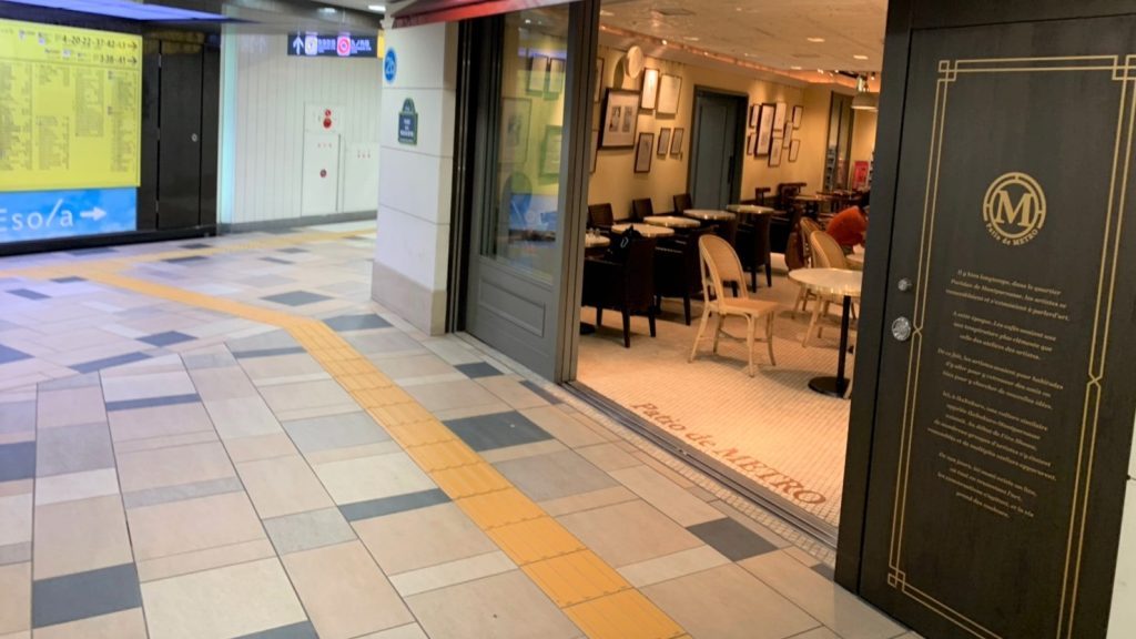 通路の脇で、カフェの入口がオープンになっている画像。
