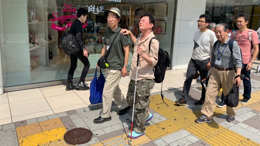 市川さんを誘導しながら歩くボランティアさんの画像