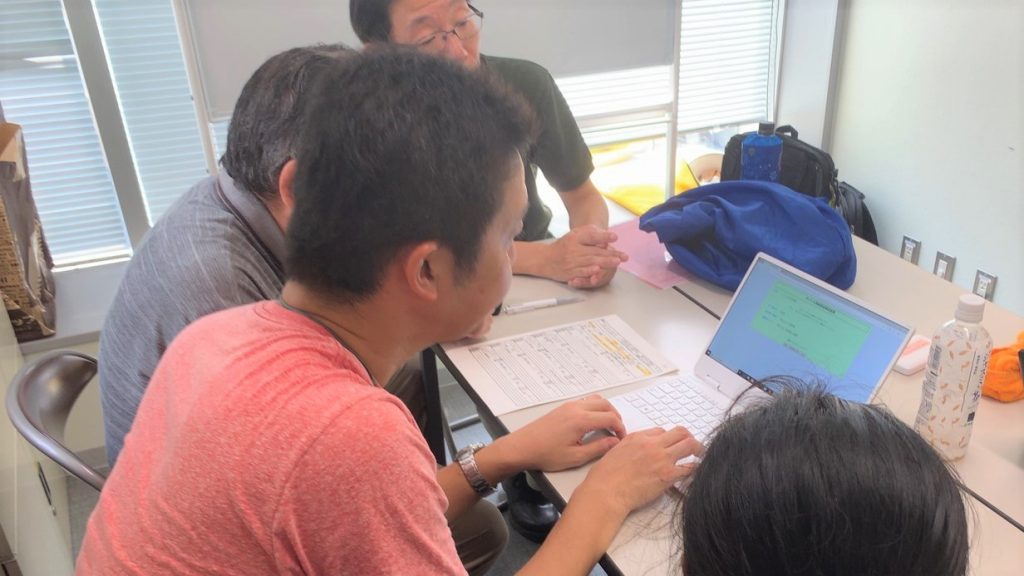 記録用紙を見ながらパソコンに入力するボランティアさんの画像