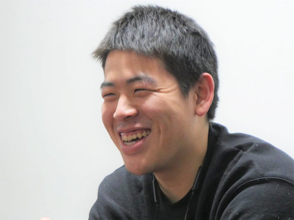 対面で話をしている山口さんをアップで撮影した画像。