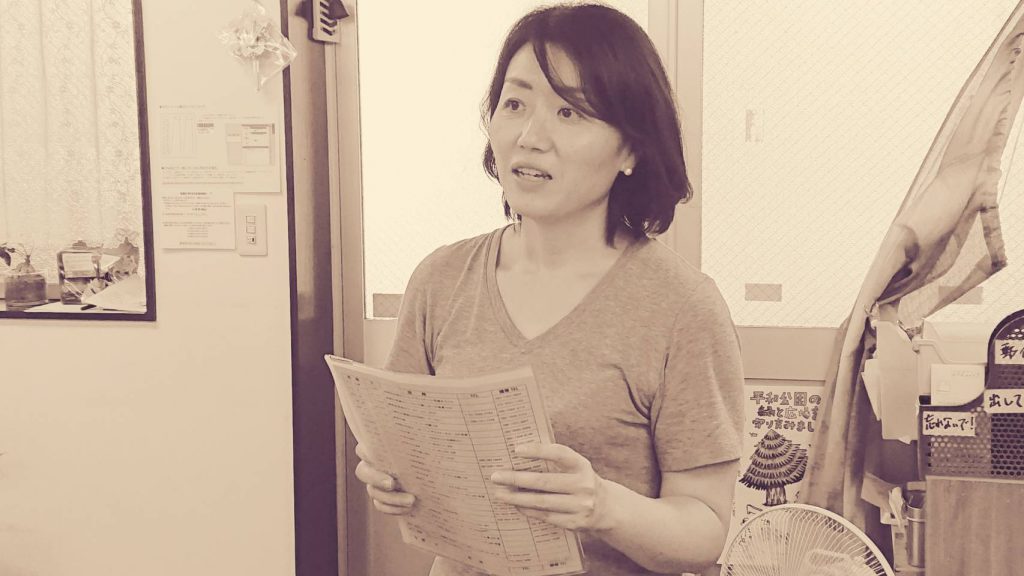 手に資料を持っている平野さんを撮影した画像。