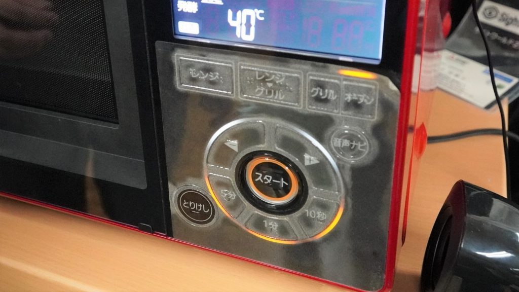 電子レンジの操作盤に点字カバーがかけられている画像。