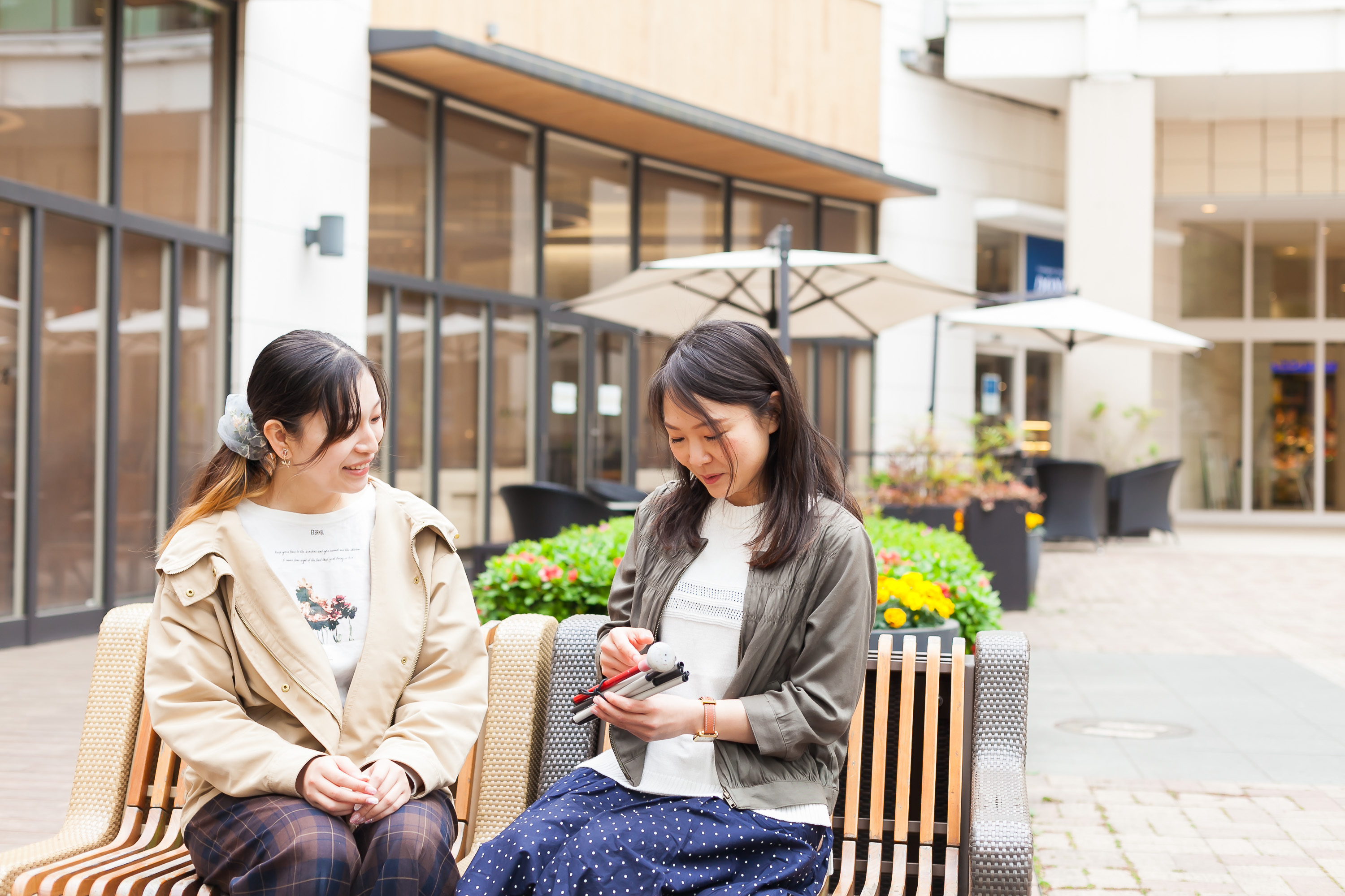 女性2人がベンチで話している写真