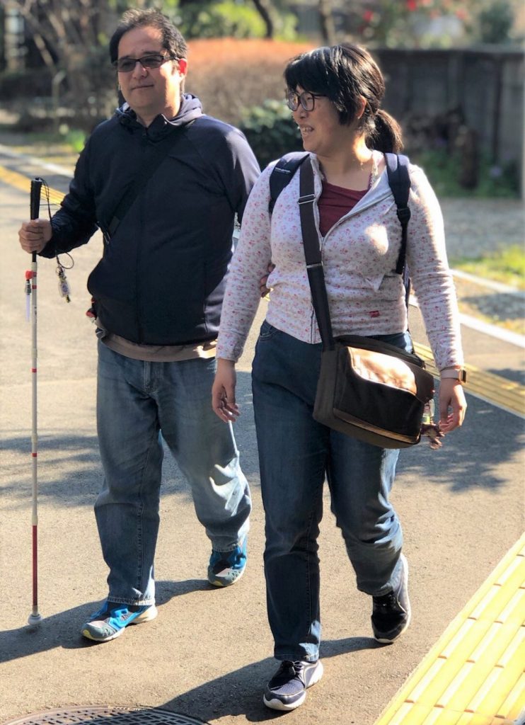 視覚障害者（彼の渡辺敏之さん）と歩行する下田ゆかりさん