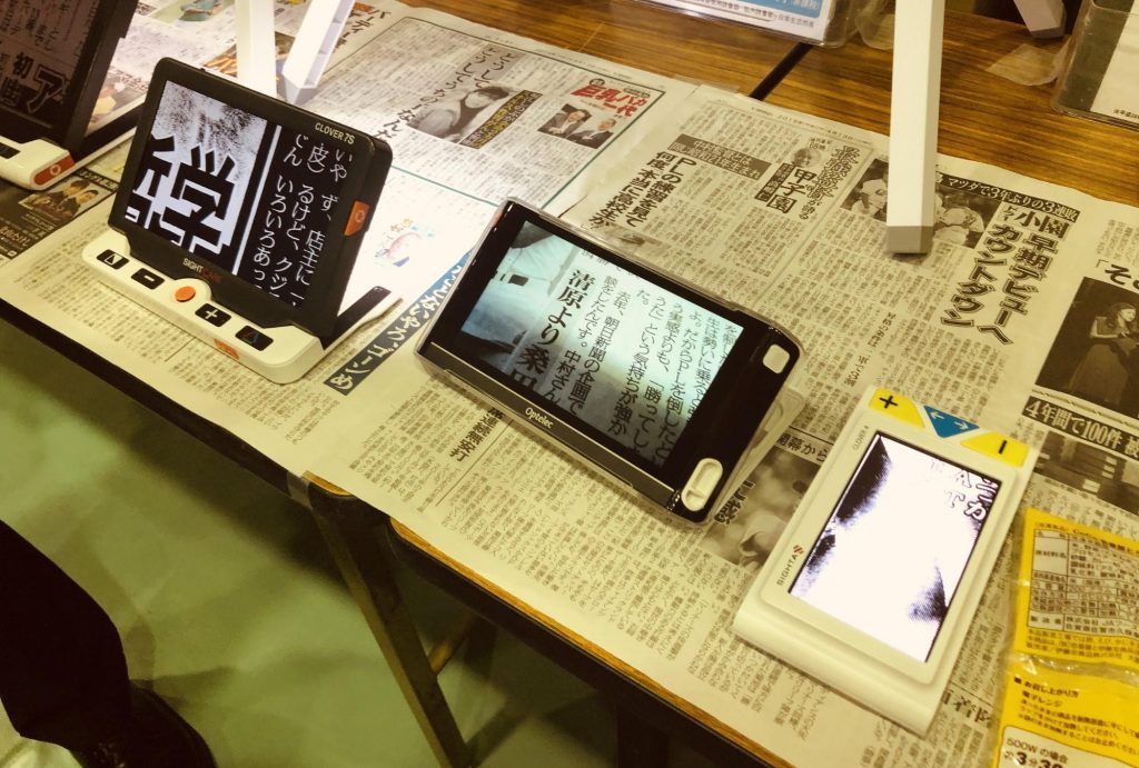 拡大読書器が机の上に3台あり、新聞を拡大している画像