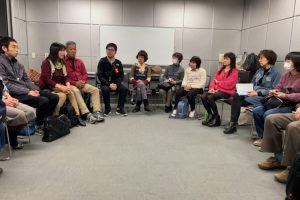 円形に並んだ椅子に参加者が座っている画像