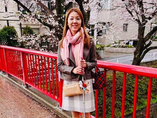 桜坂の橋の上で祈念撮影をする小林さん