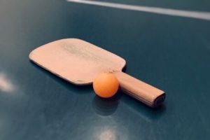 卓球台の上にラケットとボールが置かれている画像