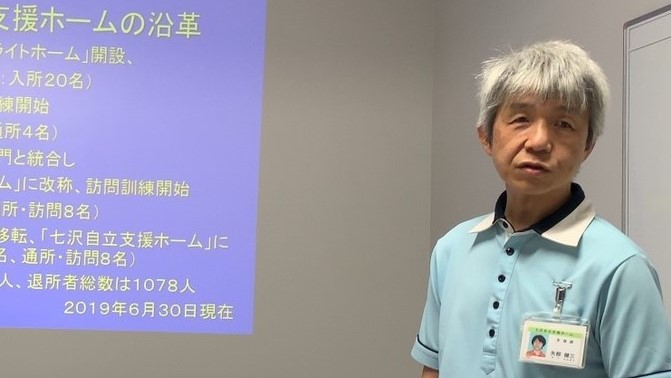 矢部さんがスライドを使い、施設の概要を説明している画像