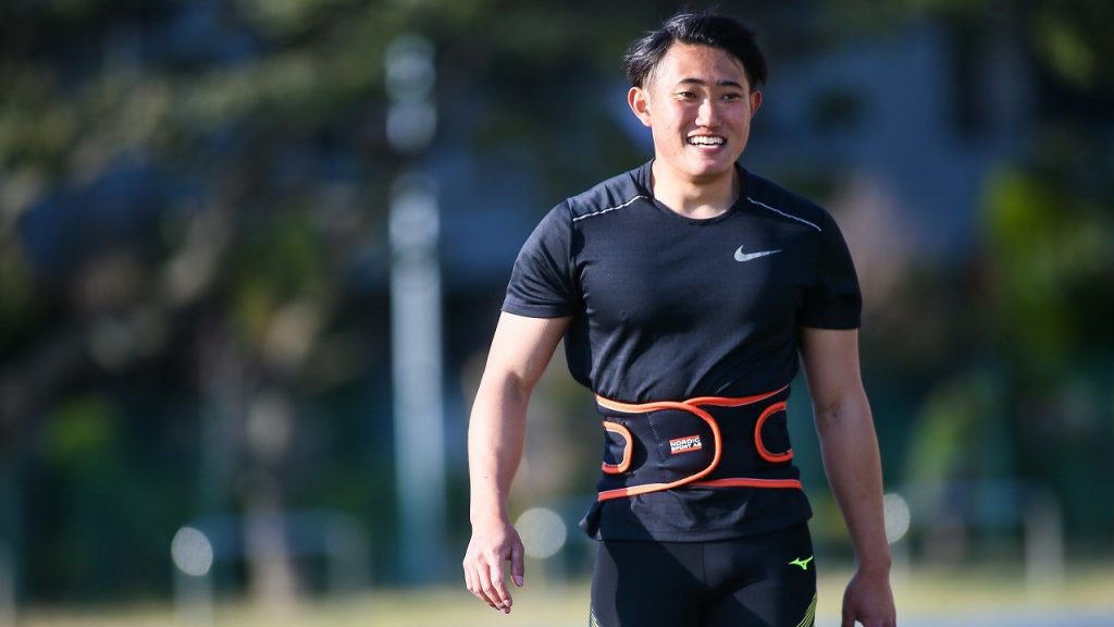 若生選手が陸上競技場を堂々と笑顔で歩いている画像。