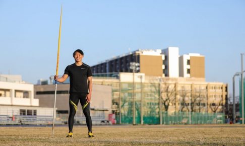 若生選手がやりをもって陸上競技場で立っている画像。