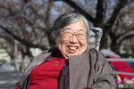 公園の桜の木の下で笑顔の吉野さんを撮影した画像。