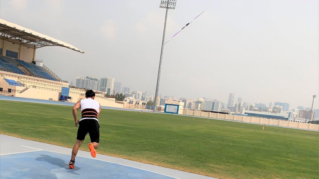 若生選手がドバイの陸上競技場でやりを投げた直後を後ろから撮影した画像。