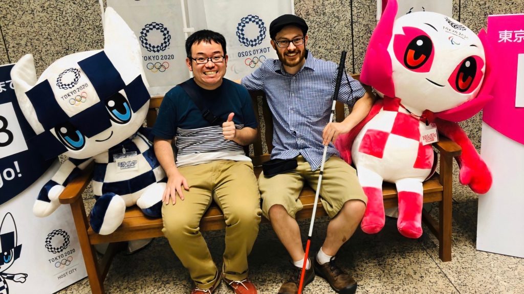 東京オリンピックパラリンピックの撮影スポットで記念撮影するジェッドさんと藤田さんの画像。