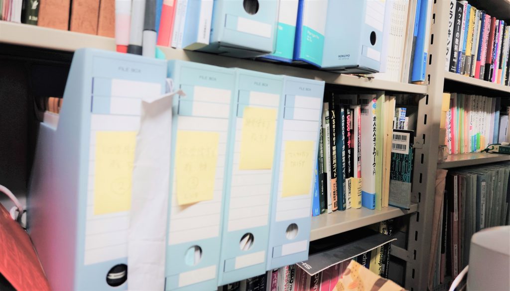 研究室の棚に書籍とファイルが並べられている画像。