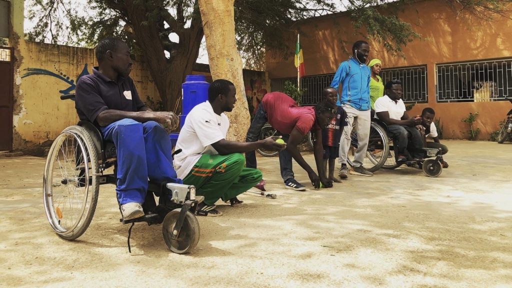 セネガルで車椅子の人や肢体不自由の人が一緒にボッチャを行っている画像。