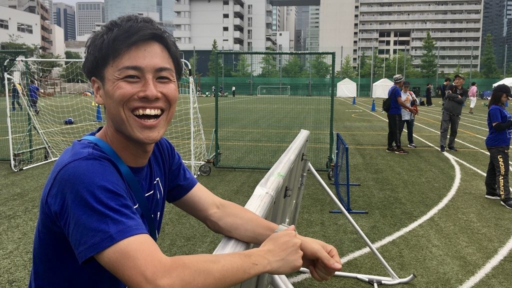 松尾さんが日本の人工芝のフットサル場で笑顔で映っている画像。