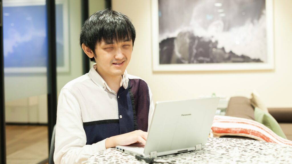 ノートパソコンを操作する野澤さん。