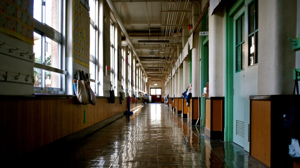 一直線に伸びる、少し暗い昼間の学校の廊下。