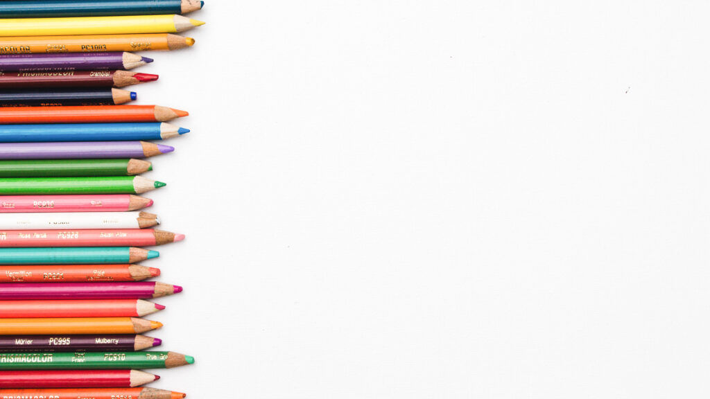 白い背景に、大小さまざまな色鉛筆が並んでいる。