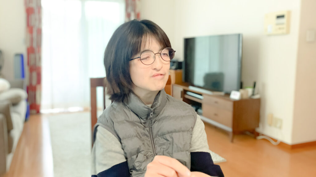 自宅で、触手話で話している田畑さんの写真。