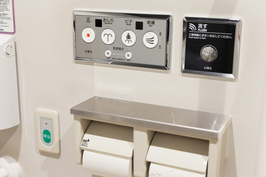 トイレにあるボタンの写真。止める、おしり、ビデ、乾燥、洗浄強さ（弱い、強い）のボタンに点字表記されている。
