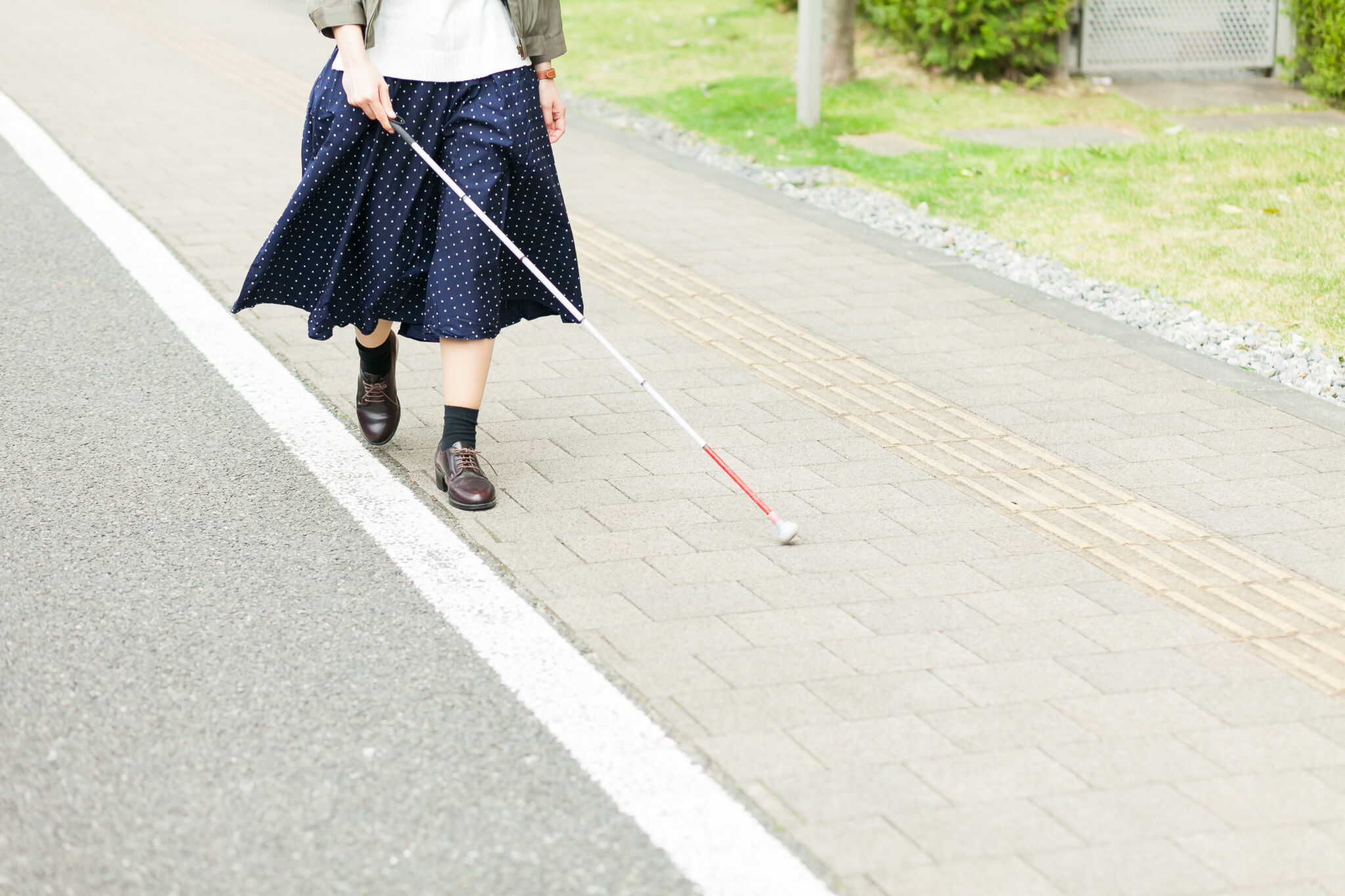 白杖を使って歩行している人の足元。