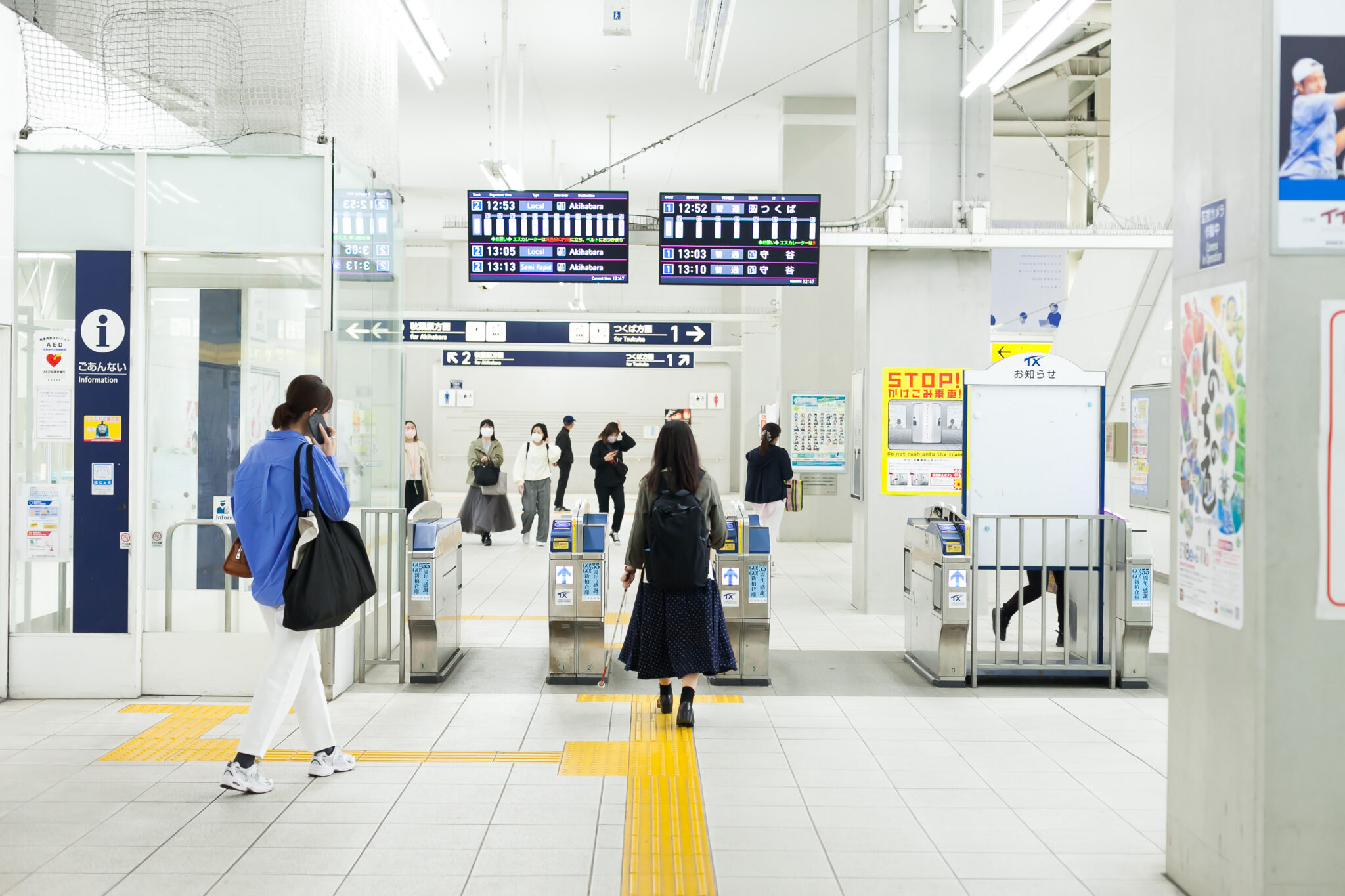白杖の人が駅の改札を通っている写真