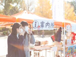 屋外のイベントテントの前で話す北原さんと谷越さん。