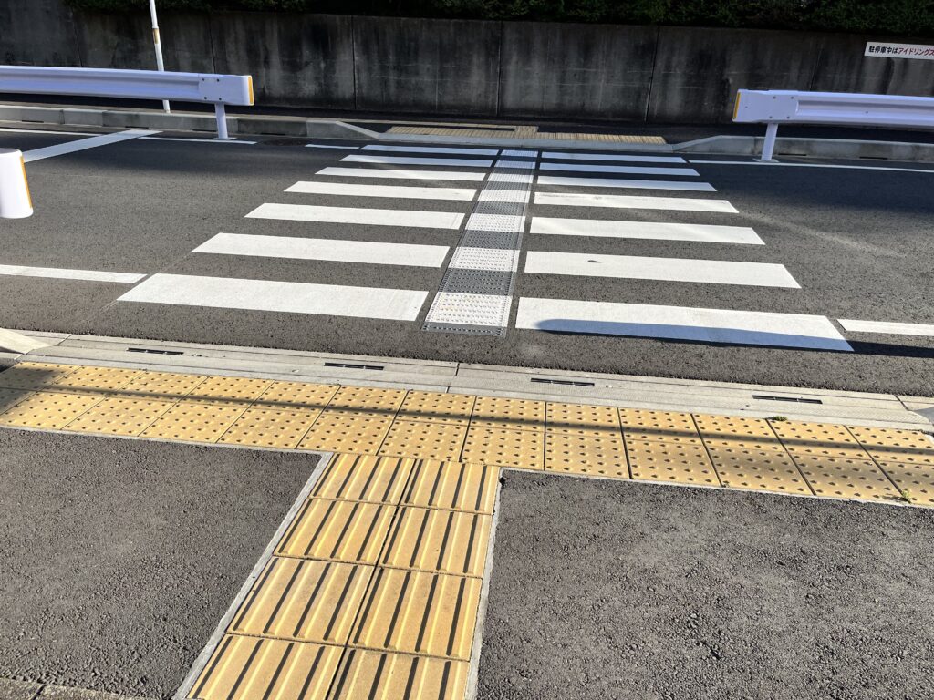 歩道と横断歩道に、連続して点字ブロックが敷設されている写真。