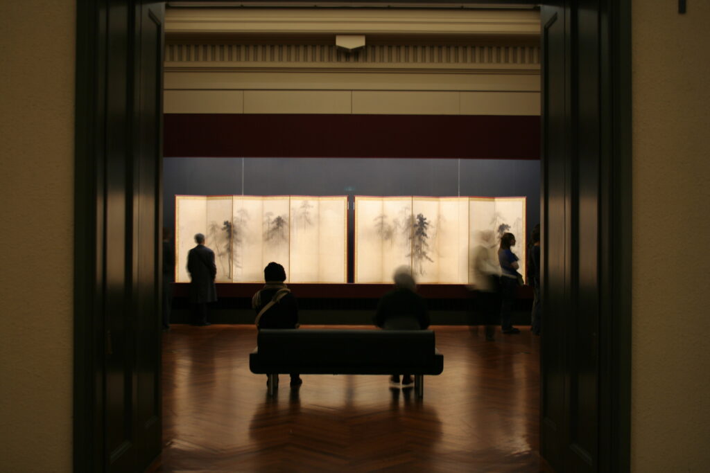 東京国立博物館の展示室。薄暗い中に、水墨画のような屏風が展示してある。
