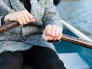 ボートを漕ぐ男性。手元がクローズアップされている。