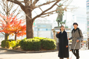 上野公園の西郷隆盛の銅像の前を歩く北原さんと谷越さん。