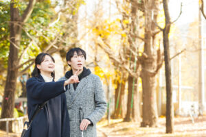 イチョウ並木の前で、右上を指さして北原さんに話しかけている谷越さん。