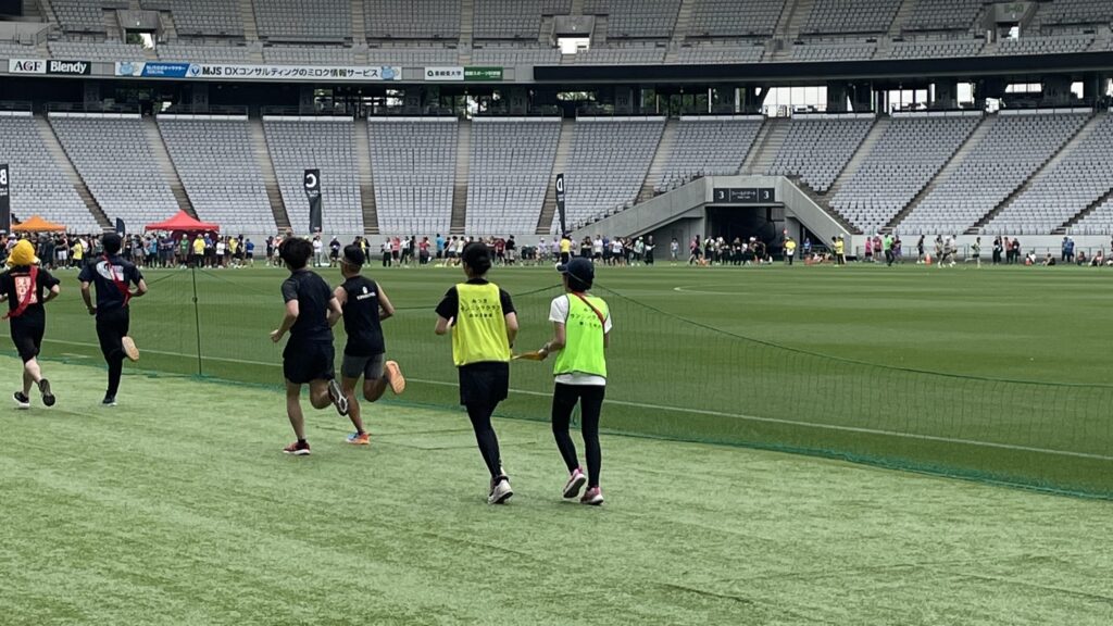 みつきランニングクラブの女性ランナーが伴走者と走っている後姿。