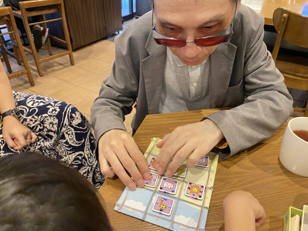 視覚障害者が、「デコどうぶつしょうぎ」の試作品をプレイしている様子。指先でコマの凹凸を確認している。