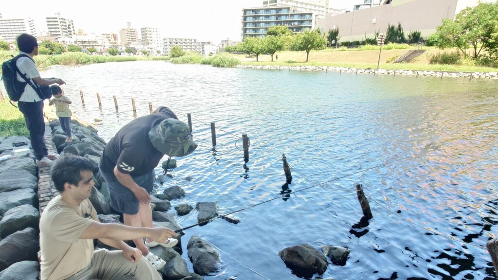 都心の河川で釣りを楽しんでいる、ガイドヘルパーの皆さんと筆者ケビンさん。